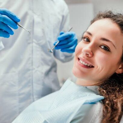 Smiling young woman receiving dental checkup. close up view. Healthcare and medicine concept.