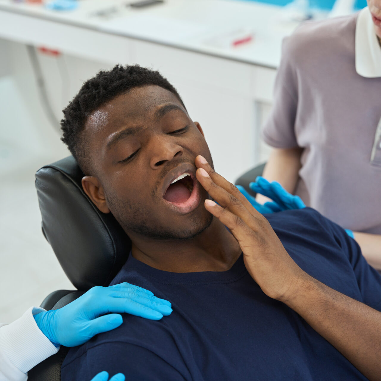 Patient with toothache sitting in chair, seeing emergency dentist in Heathmont